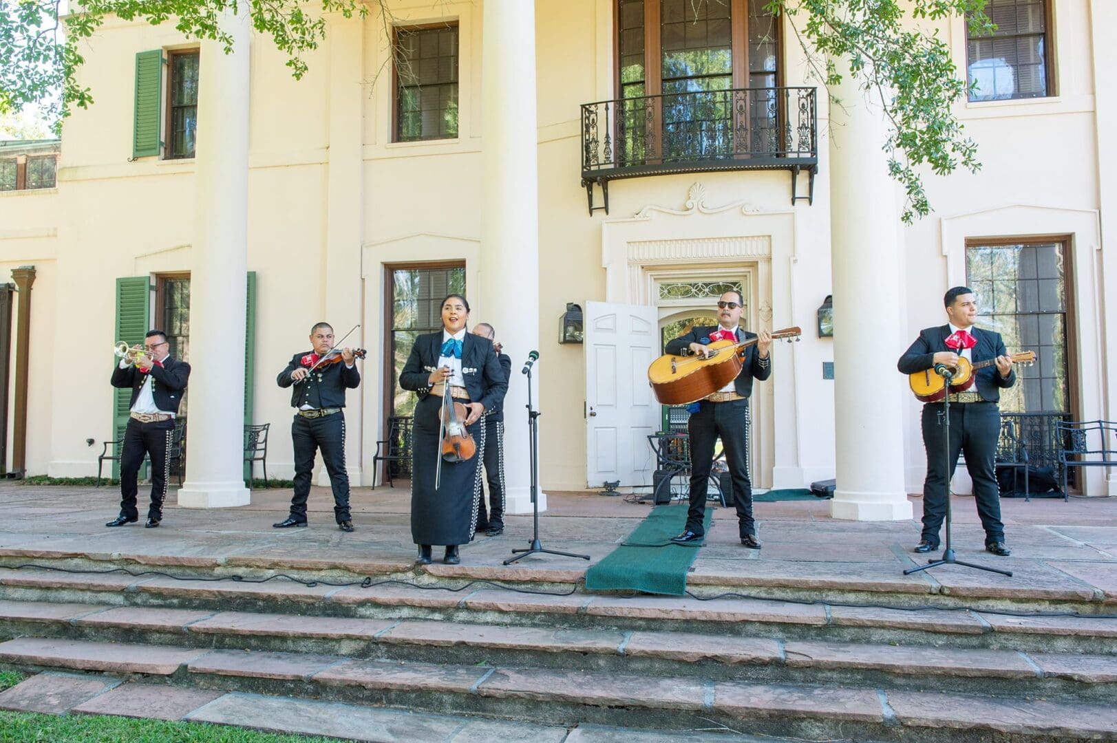 Mariachi band performing outside a building.