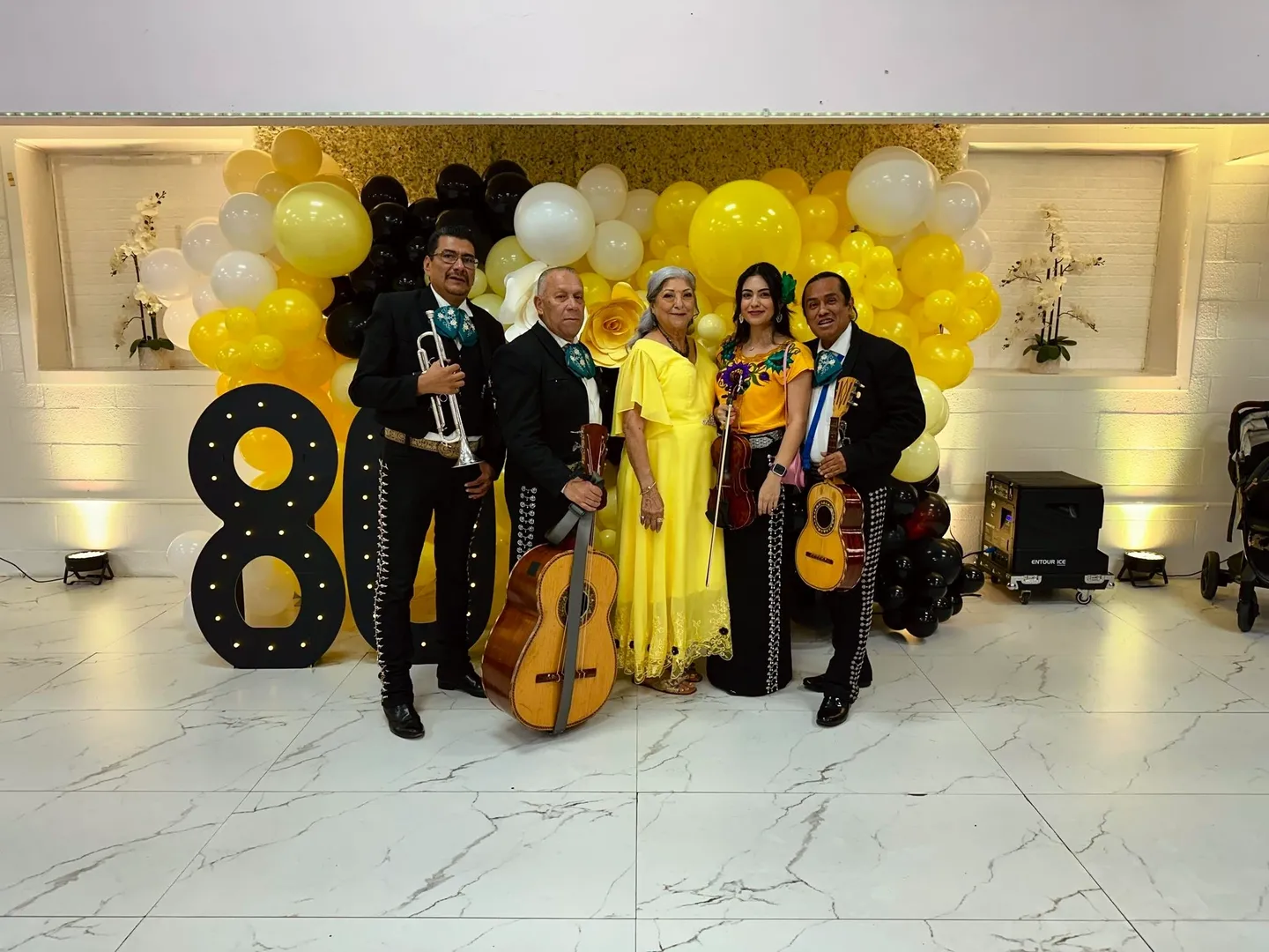 Group celebrating with balloons and musical instruments.
